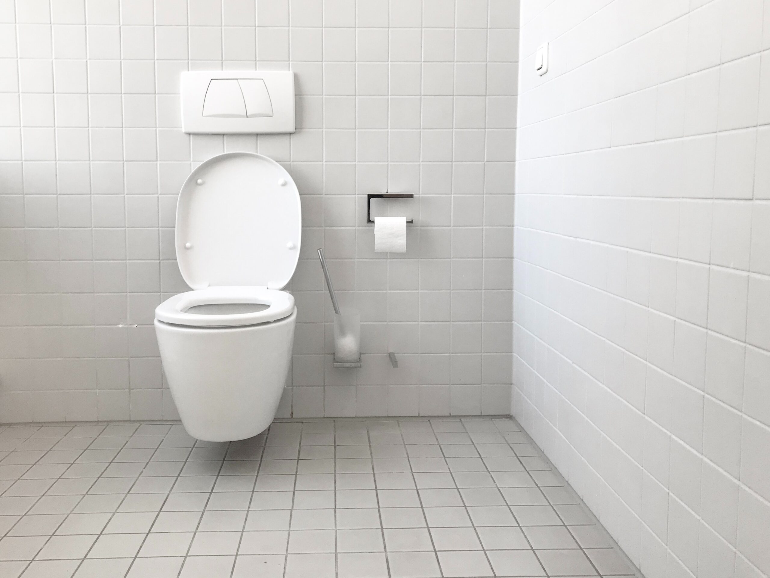 A toilet on a bathroom wall
