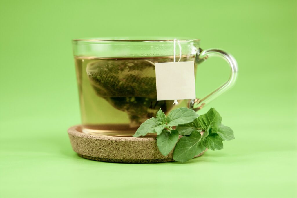 a cup of fresh green tea with mint leaves